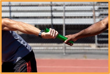 Close-up of two athletes passing a relay baton, illustrating the tax rollover provision for reinvesting gains from QSB stock sales into new qualified small business investments