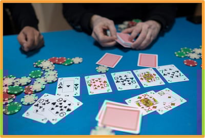 People playing poker at a casino table with cards and poker chips, representing gambling activities affected by new tax deduction rules.