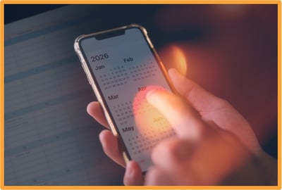 Hand holding a smartphone displaying a 2026 calendar, illustrating the upcoming gambling tax law changes scheduled to take effect in 2026.