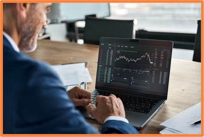Investor reviewing stock market performance on a laptop, representing capital gains as a risk factor for the alternative minimum tax (AMT).