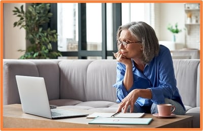 Older woman thoughtfully researching Medicare information online, showing the importance of preparing for enrollment and coverage decisions.