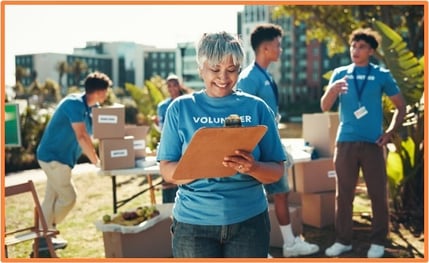 Volunteers organizing donation boxes at an outdoor charity event, demonstrating community service activities that may offer tax-deductible expenses.