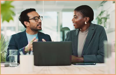 Financial advisor reviewing tax documents with a client on a laptop, illustrating support and guidance for timely tax filing and extension considerations.