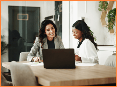 Business professionals discussing tax planning strategies at a desk with a laptop, representing collaborative decision-making for filing tax extensions.