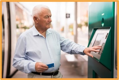 Senior citizen using a debit card at an ATM, illustrating the transition to electronic payments for Social Security and tax refunds