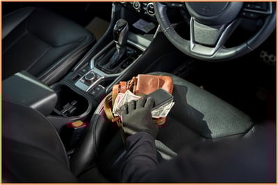 A gloved hand stealing cash and a phone from a purse left on a car seat, illustrating personal theft losses that may qualify for tax deductions.