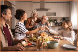 Extended family gathered around the dinner table, symbolizing the goal of beneficiary designations—to ensure assets support and care for loved ones across generations.