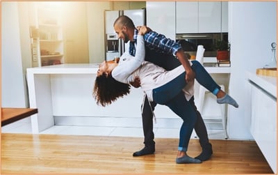 Newly married couple celebrating at home after completing financial and tax planning for their first year together.