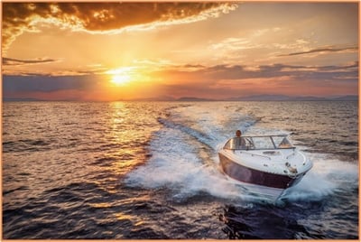 A motorboat speeding across the water at sunset, leaving a trail in its wake with orange and purple clouds above the horizon