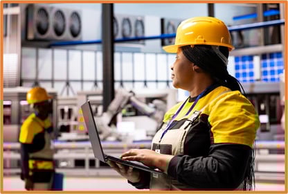 Engineer in a manufacturing facility using a laptop, representing qualified production property that may benefit from the new 100% first-year bonus depreciation under updated tax laws.