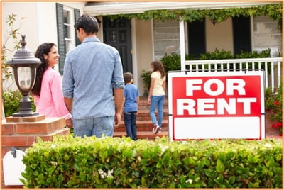 Family arriving at a vacation home with a "For Rent" sign in front, illustrating the potential for renting out a second property and the tax considerations discussed in the blog.