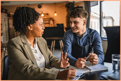 Two entrepreneurs discussing business plans and strategies, representing the importance of networking, seeking feedback, and planning when starting a small business.