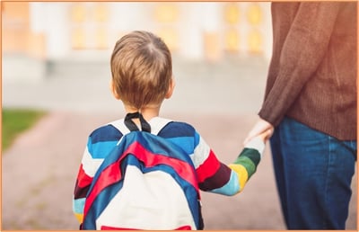 Young child wearing a colorful backpack holding an adult’s hand, symbolizing parents planning for education expenses, child tax credits, and tax benefits for dependents.