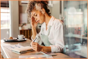 A concerned business owner reviews paperwork, preparing the necessary documents to file a tariff refund claim.