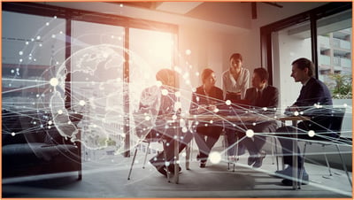 International business team meeting in a modern office, with a digital globe overlay illustrating global collaboration and strategy for transfer pricing compliance.