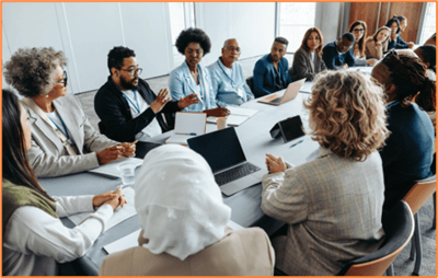 A diverse group of small business employees and owners having a discussion around a conference table, representing workplace collaboration and decision-making about retirement plan options like SEP and SIMPLE plans.