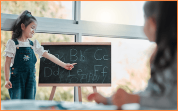 Young girl pointing at letters on a chalkboard during a learning activity, representing educational considerations for families navigating legal separation or divorce.