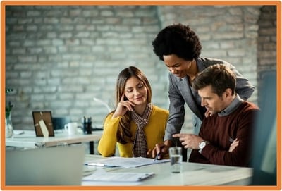 Business professionals meeting with a financial advisor, reviewing documents and discussing tax planning strategies for business interest expense deductions.