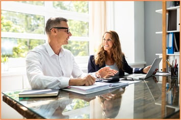 Tax advisor and small business owner discussing strategies to qualify for the Qualified Business Income (QBI) deduction.